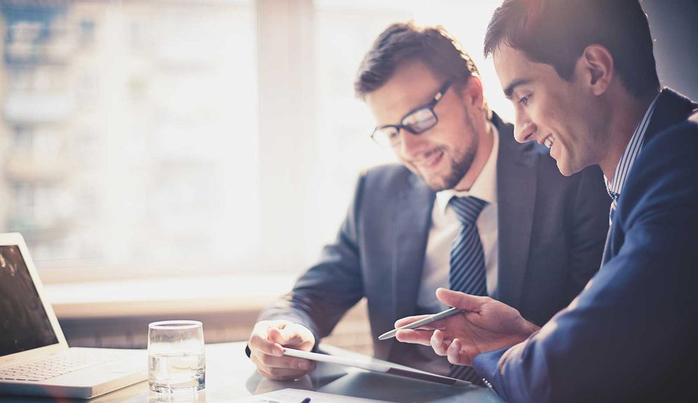Two business people reviewing figures together on a tablet